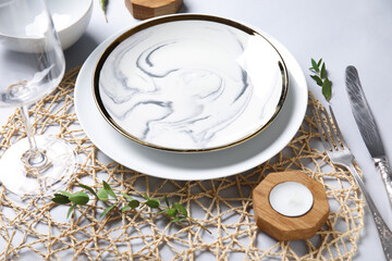 Beautiful table setting and candle on white background, closeup