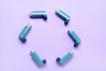 Frame made of asthma inhalers on lilac background