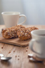 Home made cake eclairs. Traditional eclairs, profitroles classic, eclairs french. Sweet chocolate eclairs on wooden table.