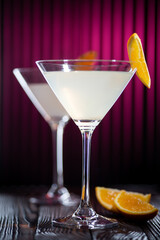 White cocktail with orange slice. Still life in a low key