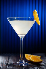 White cocktail with orange slice. Still life in a low key