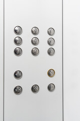 Gray elevator panel with silver buttons in a building