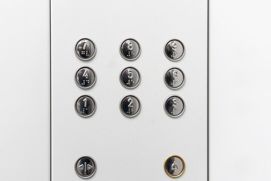Gray elevator panel with silver buttons in a building