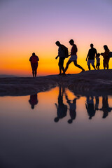 Fototapeta na wymiar People walking by the lake at sunset, silhouette, Pamukkale - Turkey