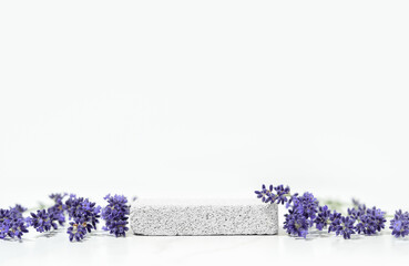 Minimal cosmetics and skin care product presentation scene made with lavender flowers and pumice stone podium. Selective focus.