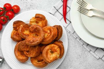 Plate with tasty Yorkshire pudding on light background