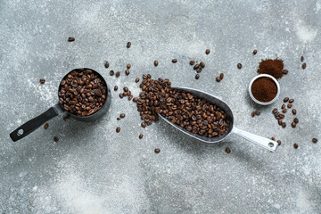 Cezve and scoop with coffee beans on grey background
