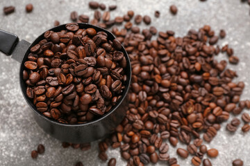 Cezve with coffee beans on grey background