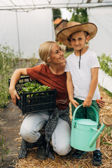 Sweet boy helps his mother in the garden.