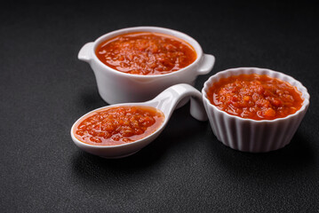 Fototapeta na wymiar Delicious spicy tomato sauce with pepper, garlic, salt, spices and herbs