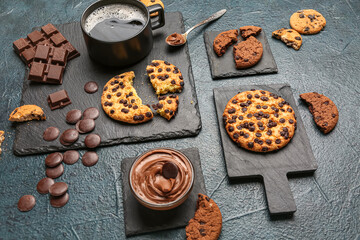 Cup of coffee with cookies, chocolate and boards on dark grunge table