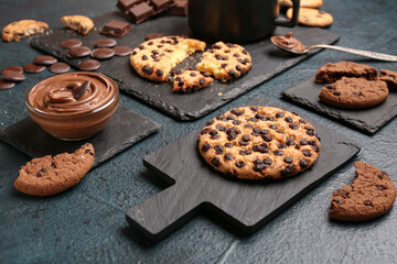 Cup of coffee with cookies, chocolate and boards on dark grunge table