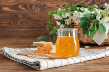 Composition with sweet honey, crackers and acacia flowers on wooden background, closeup