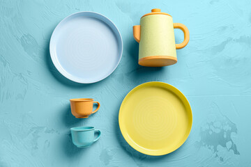Plates with cups and teapot for baby on grunge blue background