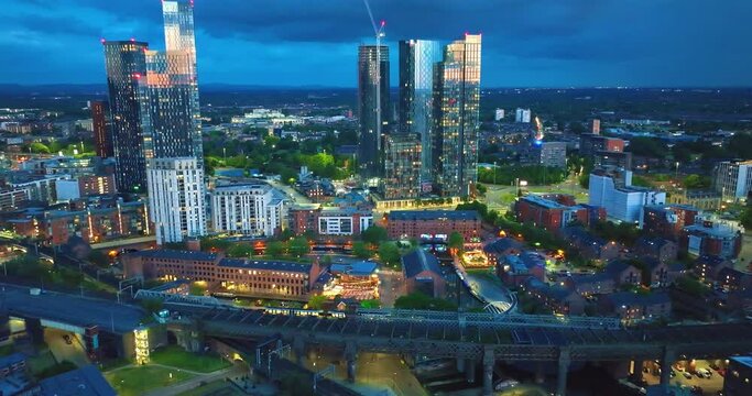 Manchester Castlefield at evening hours as trams and trains move down below. Aerial View. 