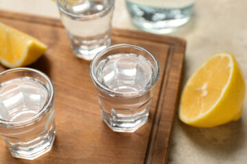 Glasses of vodka on light background