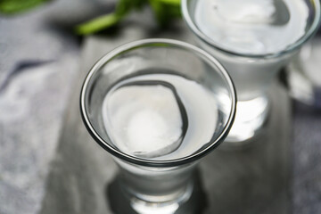 Glass of cold vodka on black background