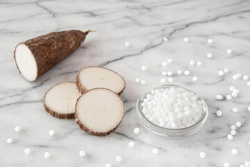 Cassava root on white background with tapioca pearls