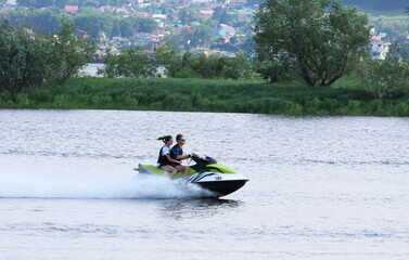 Fototapeta premium On a jet ski together, at high speed on the Volga River. A sunny summer day. Sports and recreation.