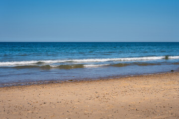Photo of a sandy beach on a nice spring afternoon, use as a background