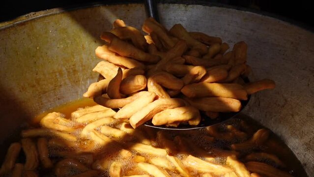 Snacks made of dough are fried in the hot oil of a kadai. Kucho Nimki (Brown Color), Handmade crunchy salty snack food. 