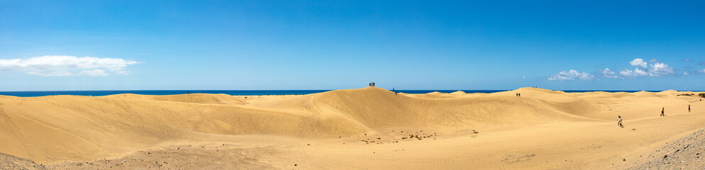 Dünen von Maspalomas auf der kanarischen Insel Gran Canaria, an der Küste des Atlantiks blauer Himmel und Wolken im Hintergrund, Panorama.