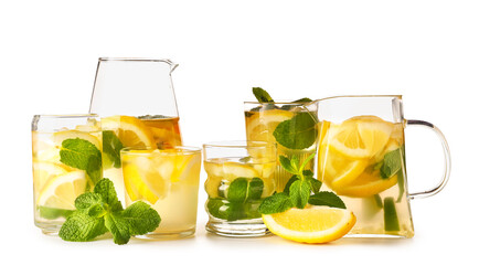 Glasses and jugs of infused water with lemon on white background