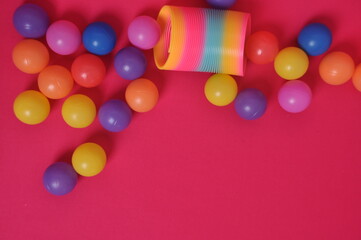 mola brinquero com bolas coloridas em fundo rosa 