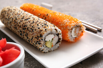 Plate with sushi rolls on grey background, closeup