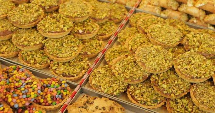 Close-up of local marketplace stall selling bakery and confectionary products. Stacks of biscuits and cookies stuffed with different sweet filling.