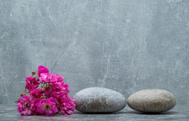 Obraz na płótnie Canvas minimalistic background with gray stones and flowers on a gray background for a product presentation background podium.