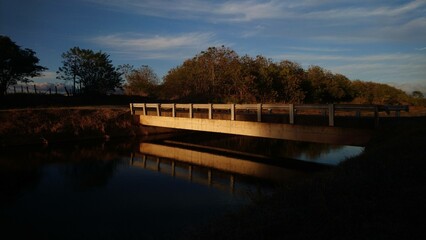Fototapeta na wymiar Lonely Bridge reflecting on the canal at dusk