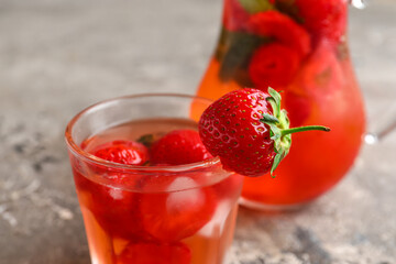 Glass of infused water with strawberry on grey background