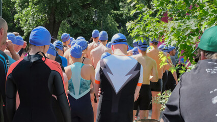 Men and women waiting for the swim at Berlin Triathlon Race 2023. They are wearing swim dresses....