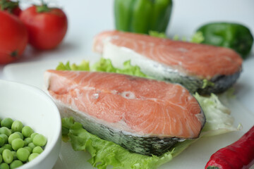 Raw, fresh salmon steak and vegetables on white 