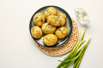 Plate of boiled baby potatoes with dill and green onion on white background