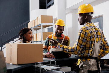 African american warehouse workers talking with stock supply manager at reception desk. Woman...