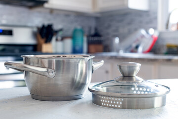 Steel saucepan with a glass lid close-up in the kitchen interior.