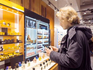 buying make up at cosmetics section in store. choosing cosmetics, perfumes, creams and shampoos, Using tester.