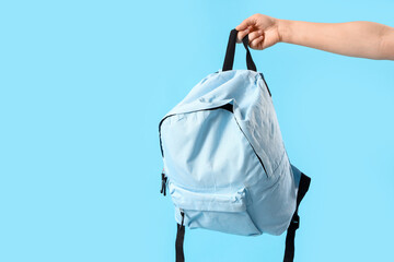 Woman with schoolbag on blue background