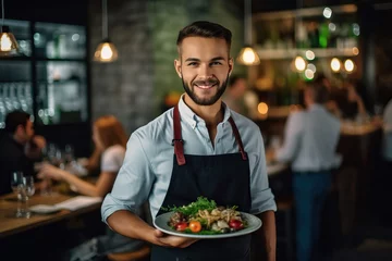 Fotobehang Photo of a man holding a delicious plate of food in a cozy restaurant © Nedrofly