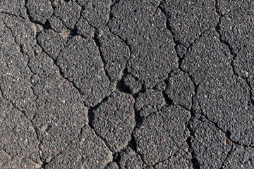 pits and cracks on the asphalt of the road