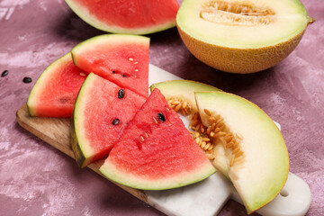 Board with pieces of fresh watermelon and melon on purple background