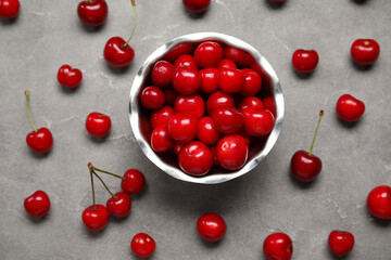 Bowl with sweet cherries on grey background