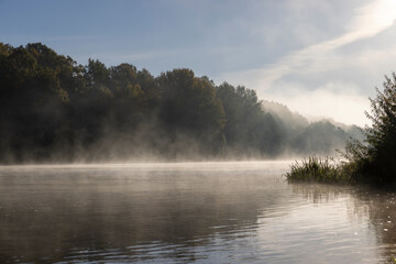 Obraz na płótnie Canvas Fog-covered river in the autumn season