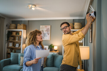Naklejka premium Couple at home connect and install cctv security surveillance camera