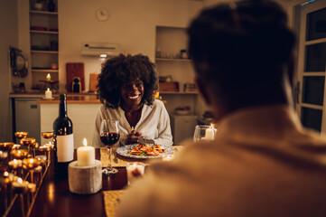 African american couple having romantic dinner date and drinking wine at home