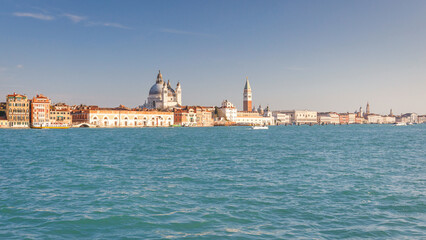 Fototapeta premium Giudecca canal in Venice with the Santa Maria della Salute basilica and St. Mark's Campanile tower, Italy, Europe.
