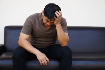 Asian man feels sad, stressed, depressed, hands covered his head. Concept, drepression, failure, disappointment, broken heart. guilty,finances crisis. Life problems.                   