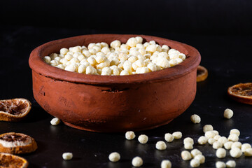 Selective focus of popped (puffed) quinoa grains in an earthenware bowl.